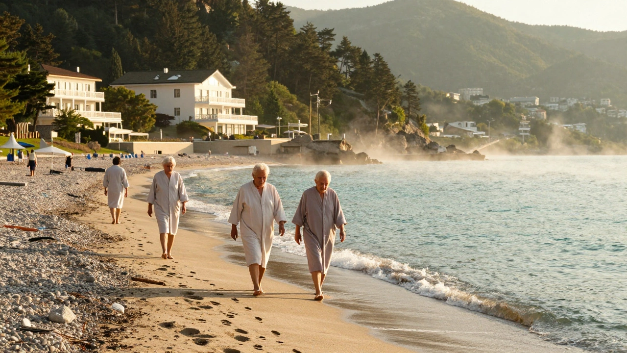 Пациенты прогуливаются по берегу Чёрного моря в Сочи после морских процедур, солнце освещает морской туман.